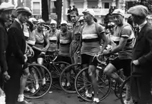 Photographie en noir et blanc montrant une équipe cycliste avant le départ d'une course.
