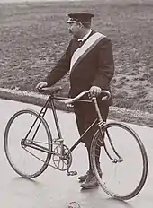 Photo d'un homme debout tenant un vélo.