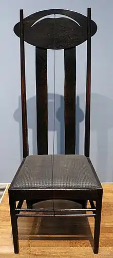 Vue d’une chaise dans les tons noirs à haut dossier.
