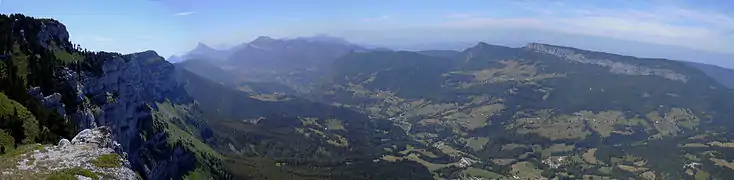 Vue panoramique plongeante sur une vallée de montagne.