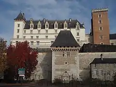 Photographie en couleurs d'un château surplombant un mur.