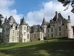 Photographie en couleurs d'un château avec de nombreuses tours et tourelles.