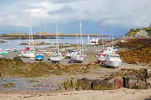 Navires échoués à Chausey : certains voiliers ont recours à des béquilles, d’autres non (dériveur au fond à gauche, béquille derrière le bateau à moteur à droite).