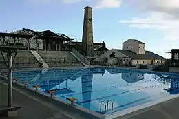 La piscine municipale de Vue Belle et en arrière-plan les vestiges de l'ancienne usine sucrière