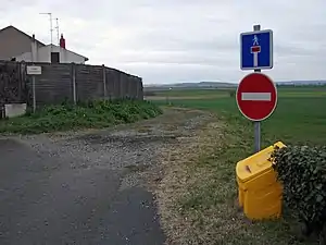 Un chemin de terre avec un panneau indiquant une impasse et un sens interdit