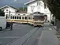 L'automotrice BDeh 4/4 313 La Berneuses de l'AL quittant la gare d'Aigle et s'engageant dans la rue de la Gare en direction de la halte Aigle-Place du Marché en 2003.