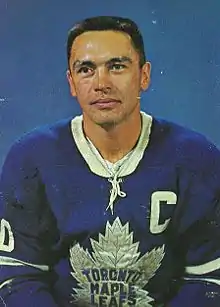 Photographie (portrait) couleur d’un homme portant un maillot de hockey sur glace bleu