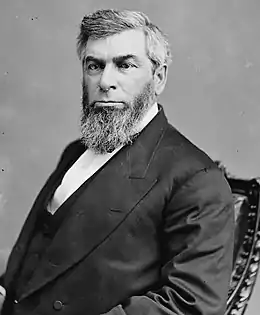 Photographie d'un homme avec une épaisse barbe poivre et sel