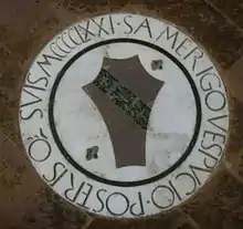 Photographie d'une pierre tombale au centre de laquelle se trouve un écu familial et autour de laquelle il est écrit « S. Amerigo Vespucio Posteris o suis MCCCCIXXI. »