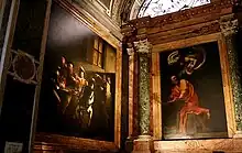 Vue en contre-plongée de deux tableaux décorant les murs d'une chapelle ornée de marbres.