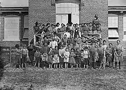 Photographie d'un groupe d'enfants devant leur usine
