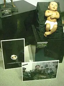 Modèle de bébé dans une vitrine à côté d'autres objets liés au film.