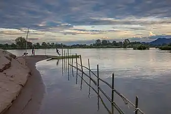 Enfants jouant sur les rives du Mekong, au soleil couchant