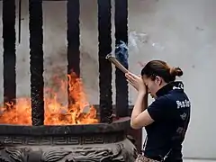 Une femme se recueille en brulant de l'encens dans le temple du Bouddha de jade. Mai 2015.