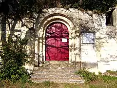Photographie en couleurs d'un portail en bois peint en rouge.