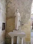 Photographie en couleurs de la statue d'un personnage religieux.