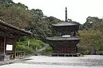 Petit bâtiment en bois à un étage en forme de pagode avec une base carrée et un étage supérieur rond.