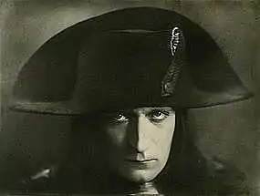 Photographie en noir et blanc de la tête d'un homme coiffé du chapeau caractéristique de Napoléon premier.