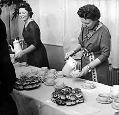 La reine Juliana et la princesse Beatrix servant des krentenbollen et du lait au chocolat pour leur équipe, le 22 décembre 1960 (photo : Harry Pot, Anefo).