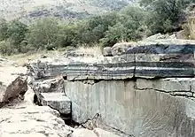 Chromitite (noir) et Anorthosite (gris clair), intrusions stratifiées dans la zone UG1 du CIB, affleurement de la rivière Mononono près de Steelpoort.