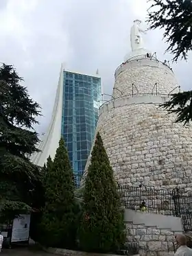 La basilique (à gauche) avec sa baie vitrée, et le sanctuaire surmonté de la statue de Notre-Dame du Liban (à droite)