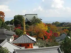 Plusieurs bâtiments bouddhiques parmi les arbres aux couleurs d'automne.