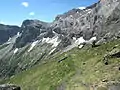 Chemin des mines envahi par l'herbe dans la partie centrale du cirque et sa traversée de la falaise sud