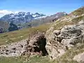 Sur le plateau de Liena, tranchée d'extraction du plomb argentifère à la limite entre le grès rouge à gauche et le granite à droite ; au loin, le massif du Mont-Perdu