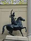 Statue d'une guerrière à cheval, à gauche de la porte d'entrée.