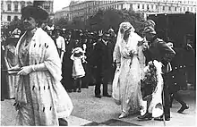 La Comtesse Clam-Gallas (à gauche, en manteau d’hermine) arrivant à la Votivkirche de Vienne à l’occasion du mariage d’une de ses sept filles, (couple de droite) la Comtesse Gabrielle Clam-Gallas au  prince Adolf d’Auersperg. Les mariages de la haute aristocratie donnent lieu à d’exceptionnels évènements mondains.