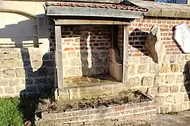 Ancien puits public sur le mur de l'église.