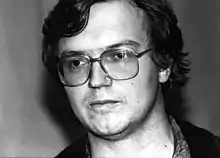 Photo en noir et blanc d'un homme portant des lunettes.