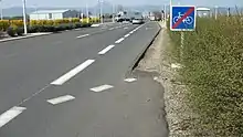 Sur une route départementale, fin d’une bande cyclable à droite avec le panneau
