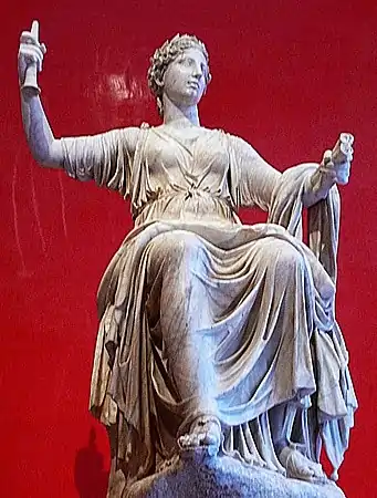 Photo d'une statue en marbre représentant une femme portant une toge et en position assise.