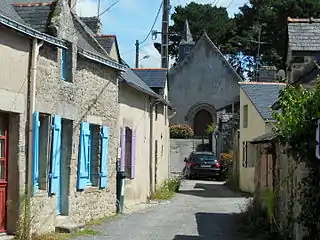 Vue d'une rue de village avec des façades en moellons de granit.