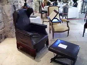 Siège de nécessité : chaise percée sur roulettes, repose-pied, pupitre et repose-chandelier. Époque Louis-Phillippe (XIXe S.), provenant de la salle du bain de Château d'Eu.