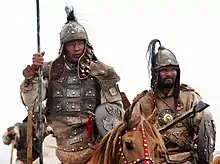 Hommes armés de lances, boucliers, casques et protections corporelles de cuir.
