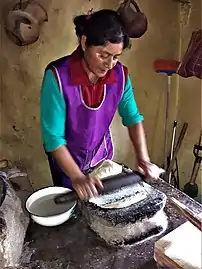 Isabel Nicolás, une femme Ñuu Savi (mixtèque) moulant de la pâte de maïs dans le yooso (metate en mixtèque) lors de la fabrication de tortillas.