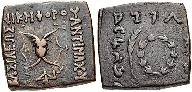 Monnaie d'Antimaque II avec une gorgone et l'inscription ΒΑΣΙΛΕΩΣ ΝΙΚΗΦΟΡΟΥ ΑΝΤΙΜΑΧΟΥ : « Du roi Victorieux Antimaque ». Au revers : une couronne de victoire et une légende en kharoshti.