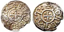 Photo des deux faces d'une pièce de monnaie usée. Les deux faces présentent des motifs similaires, des lettres majuscules en cercle autour d'une croix.