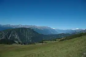 Le col de Joux vu du remonte-pente de Palasinaz, à gauche la Tête de Comagne, en bas la mine de Chamoursière et, à droite au fond, la vallée de la Doire Baltée et le Mont-Blanc.