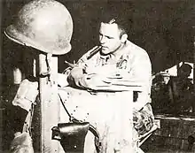 Un homme en uniforme attablé et regardant des documents.