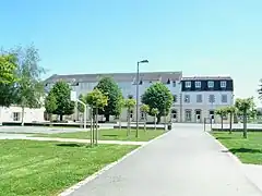 Photographie en couleurs prise de l'allée face au bâtiment de l'école.