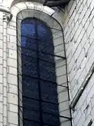 Photographie en couleurs d'un mur masquant partiellement l'encadrement d'une fenêtre.