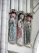 Photographie en couleurs d'un groupe de trois sculptures féminines polychromes dans une église.