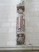 Photographie en couleurs d'une sculpture murale polychrome dans une église, un évêque avec son manteau et sa mitre.