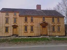 La ferme de Barrett, un long bâtiment en bois avec de nombreuses fenêtres.