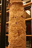 Photographie d'une colonne antique représentant une vigne et ses raisins, reconstituée d'après ses éléments.