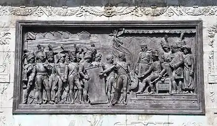 Le plan de la colonne de la Grande Armée est présenté à Napoléon Ier, bas-relief en bronze au piédestal de la colonne de la Grande Armée, à Wimille.