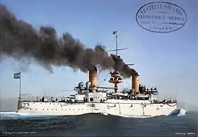 Photo colorisée montrant un croiseur blanc filant à toute vitesse, vu depuis tribord.